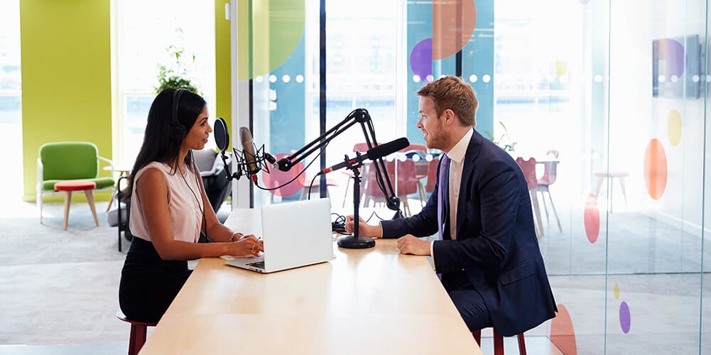 Interviewer converses with a guest while recording her popular legal podcast.
