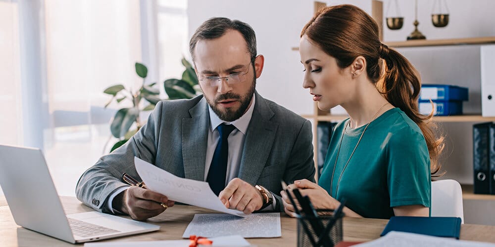 Attorney sits with his client and reviews documents to help prepare for the deposition