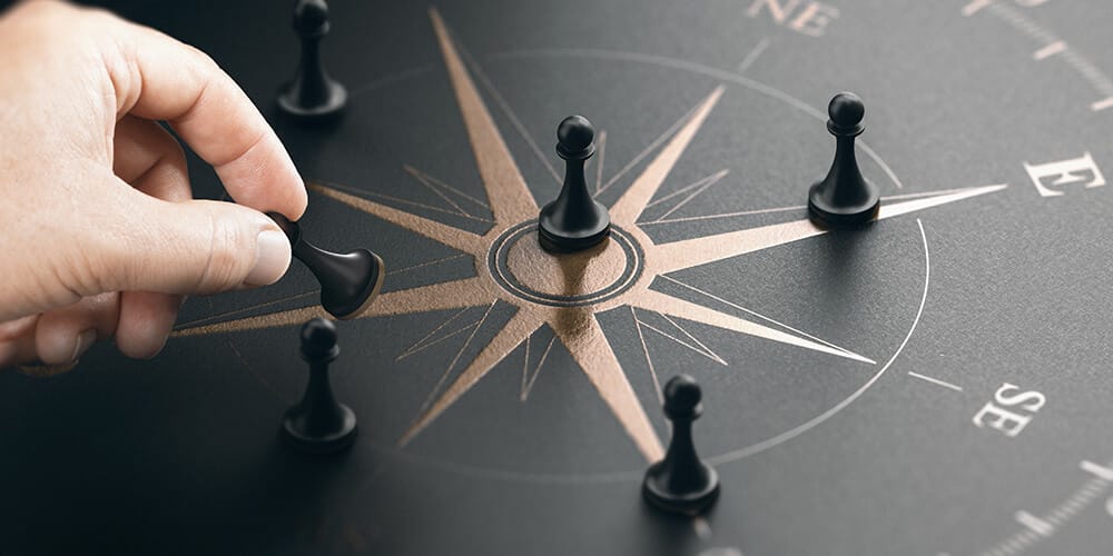 Chess pieces placed across the different points of a compass illustrates the change in direction occurring in legal companies in 2020.