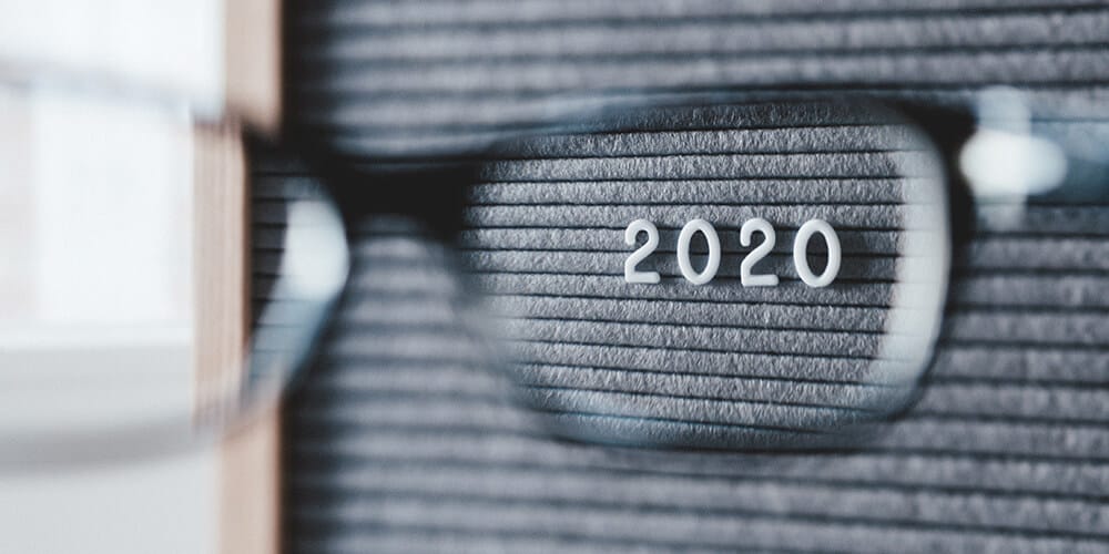 Photo of a letterboard taken through the lens of a pair of glasses, representing the act of eDiscovery. The year ‘2020’ is in focus on the letterboard.