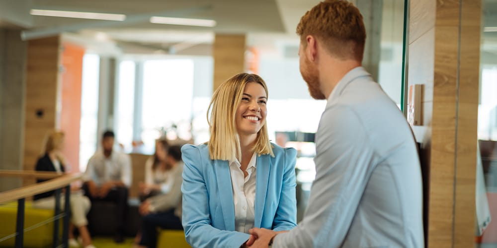 Young attorney shakes hands with her boss after landing her first law firm partnership.